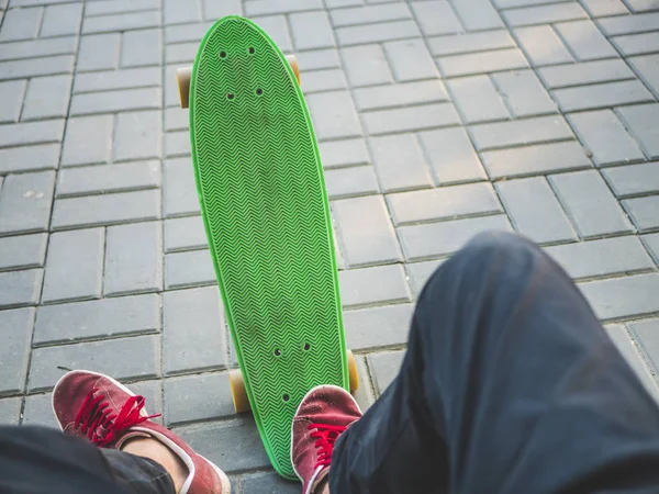 first person view of man sitting on the bench with skateboard