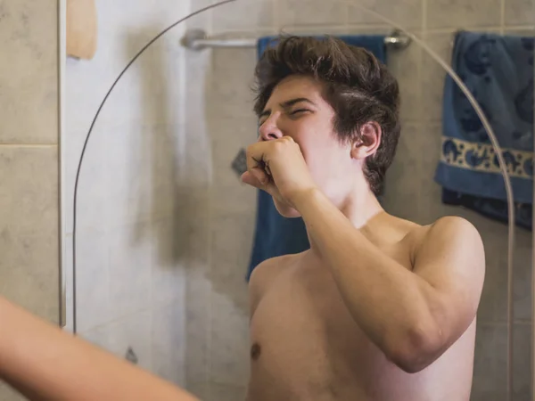 年轻裸男男孩早上在浴室镜子前打哈欠 — 图库照片