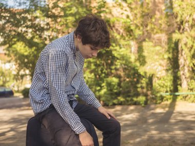 büyük Bagaj büyük açık çanta yaz şehrin sokak üzerinde oturan yorgun genç genç adam