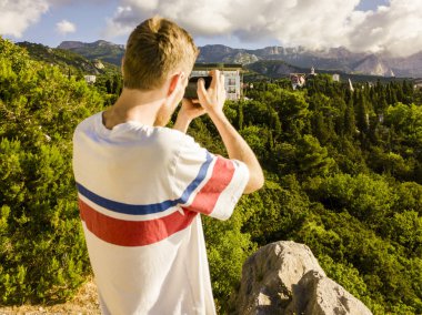 dağ manzara fotoğrafçılığı alarak kamera ile genç adam portresi