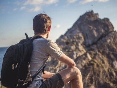 arkadan görünüşü adam uzak dağ başında el ile seyir sırt çantası ile