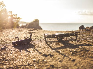 deniz güneş ışığı ile tonlu arka plan üzerinde dağ yeryüzünde döşeme dron ve denetleyicisi oyun çubuğu yukarı kapatın