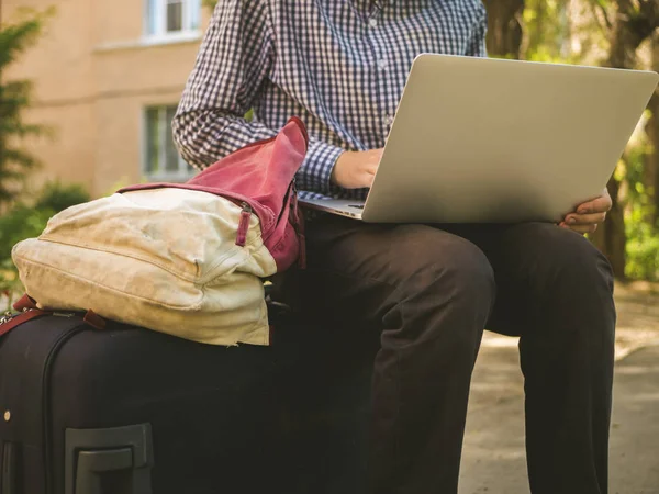 Nahaufnahme Person Sitzt Auf Reisekoffer Gepäckarbeit Auf Laptop Draußen Auf — Stockfoto