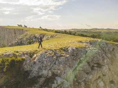 Hava geniş açı panorama görünümünü dağ kenar cliff üzerinde yürüyen adam 