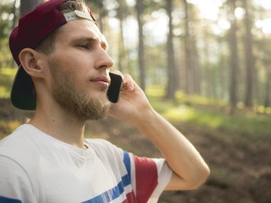 Doğa frest Avrupa İsviçre'deki yürüyüş telefonla konuşurken şapkalı Genç sakallı hippi portresi kapatın