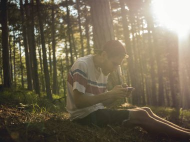 hipster kap ve milli park ormanda oturan ve sosyal ağ telefonu sohbet rahat kıyafetler oung sakallı