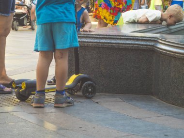 sokakta bir yaz gününde çocuğun bacakları ve tekme scooter kadar yakın
