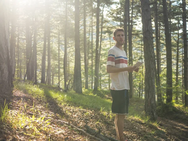 genç öğrenci notlarını kağıda yazı ve ödev düşünme ormandaki yürüyüş 