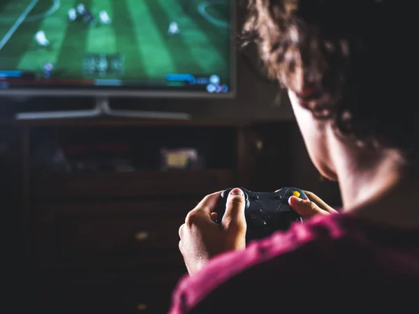 大画面でスポーツ ゲームを再生するコンソールのジョイスティック コント ローラーで若い男を閉じる — ストック写真