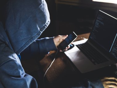 dizüstü bilgisayar ve cep telefonu ile çalışan bilgisayar önünde oturup başlıklı anonim kişi 