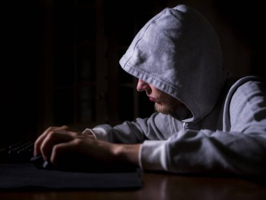 gece geç klavye pc monitör önünde metin yazarak kukuletalı adam portresi