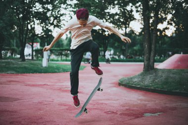 Erkek kaykaycı deli yapıyor şehir sokak parkta bir yaz gününde hileci.