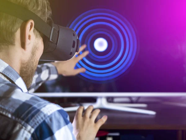 back view of person hands gestures waving in front of the screen monitor using virtual reality glasses