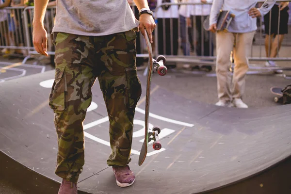 Young rider holding a skateboard on competition tournament — Stock Photo, Image