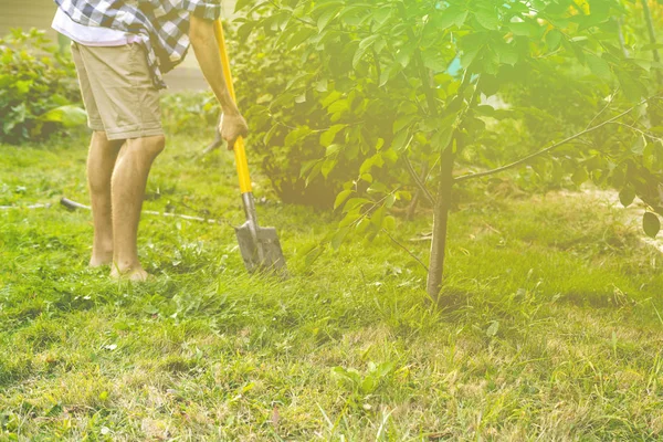 Close-up van persoon benen werken in tuin en graven met behulp van schop s — Stockfoto