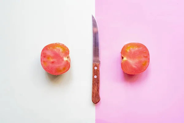 Креативный минималистский макет свежего сырого помидора на мягком фоне с ножом f — стоковое фото
