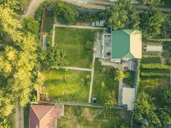 Aerial drone shot of summer countryside cottage with garden