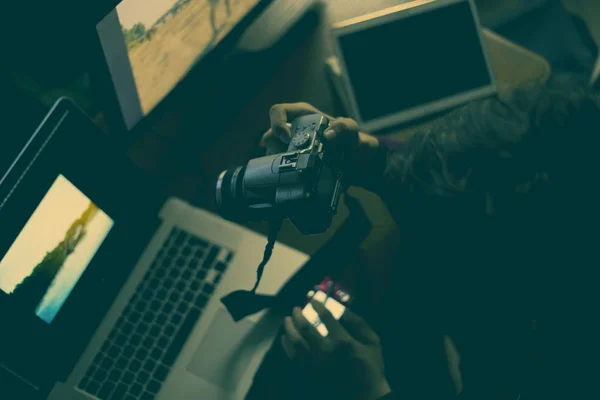 Молодой фотограф-мужчина делал снимки в домашней студии на ноутбуке и настольном компьютере. — стоковое фото