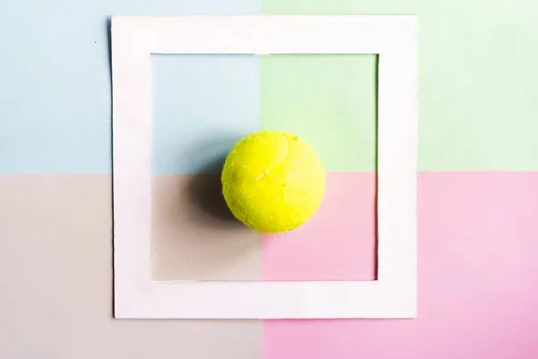 creative flat lay with tennis bal isolated in white frame on color background mock up, creative idea concept f