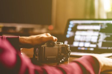bir kamera ve prcessing onun fotoğrafları stüdyo f içinde laptop üzerinde tutan genç erkek fotoğraf