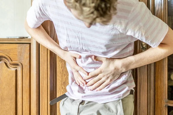 Young man holding touching stomach, suffer from strong stomache f — Stock Photo, Image