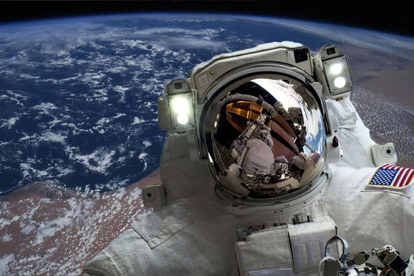 Astronaut flying in outer space near planet earth doing some work near space ship, elements of this image were taken from NASA photos f — Stock Photo, Image