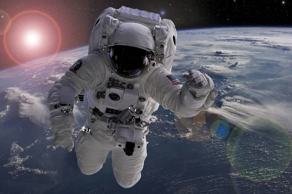 Astronaut vliegen in de ruimte in de buurt van planeet aarde gedoe sommige werkzaamheden in de buurt van ruimteschip, elementen van dit beeld waren ontleend aan Nasa foto's f — Stockfoto