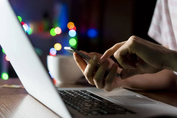 Jeune homme chat dans le réseau social avec des amis en utilisant le téléphone et l'ordinateur portable tard dans la nuit d — Photo