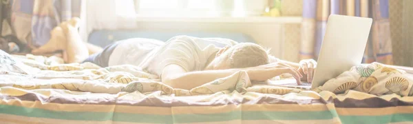 Молодой человек лежал и спал на кровати солнечным утром после работы на ноутбуке ночью f — стоковое фото