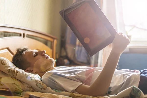 Liegend und schlafend auf dem Bett zu Hause und morgens Buch lesen — Stockfoto