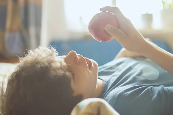 person sleeping and lying in the bed abd bite and eat fresh apple f