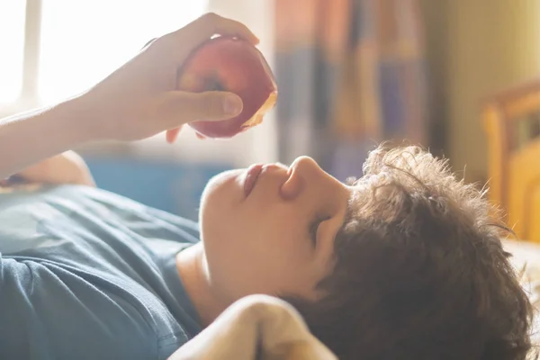 person sleeping and lying in the bed abd bite and eat fresh apple f