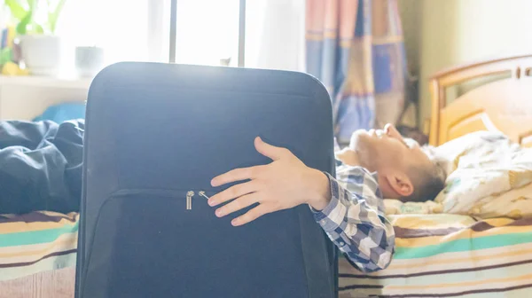Matkustava liikemies levätä hotellihuoneessa, makaa sängyssä matkatavaroiden vieressä f — kuvapankkivalokuva
