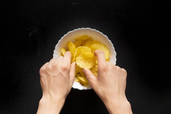 Hand Pflücken nehmen Sie die frittierten Kartoffelchips vom Teller f — Stockfoto