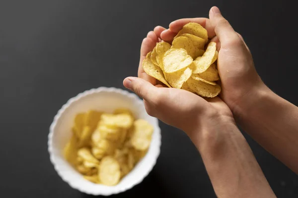 Felső kéz kupa gazdaság sós chips, a sötét háttér f — Stock Fotó