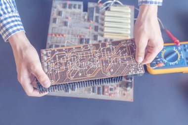 bir elektrik devre kartını tamir düzeltme tutan el ve elektronik kavramı f bir araya