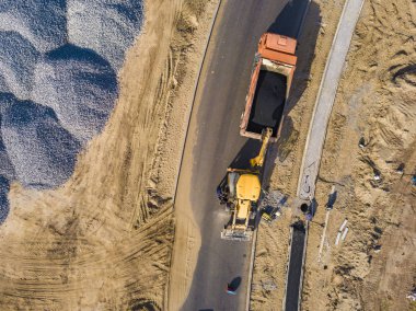 Endüstriyel Ekskavatör üst hava görünümünü asfalt yol f onarmaya Damper parça koymak.