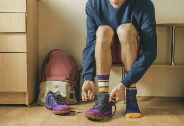 Cropped view of sportsman hands tie shoelaces of sneakers at the locker room i — Stock Photo, Image