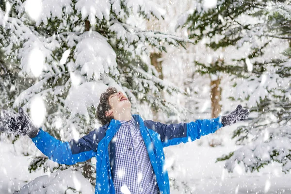 Adolescente feliz gostando de queda de neve no inverno floresta nevada f — Fotografia de Stock