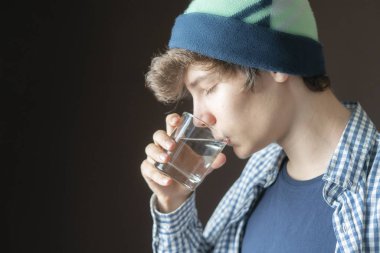 yakışıklı genç susuz erkek cam B'den filtred su içme