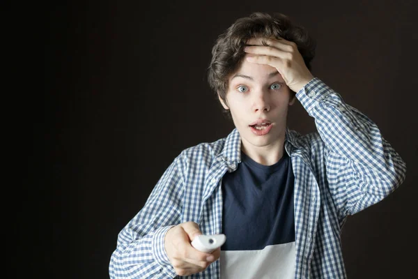 Espantado jovem masculino assistindo programa de tv e sendo surpreendido b — Fotografia de Stock