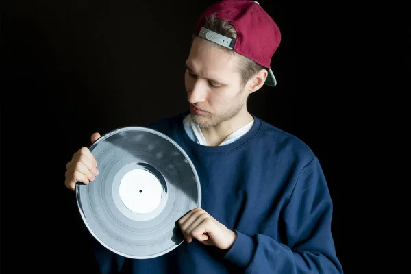 Hipster mâle tenant du vinyle vintage dans sa main et rêvant de musique — Photo