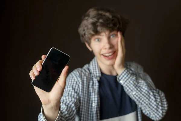 Jeune homme prenant selfie de lui-même avec son téléphone portable sur fond sombre b — Photo