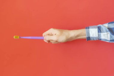 renk arka plan f üzerinde bir diş fırçası tutan kişinin el üstten görünüm