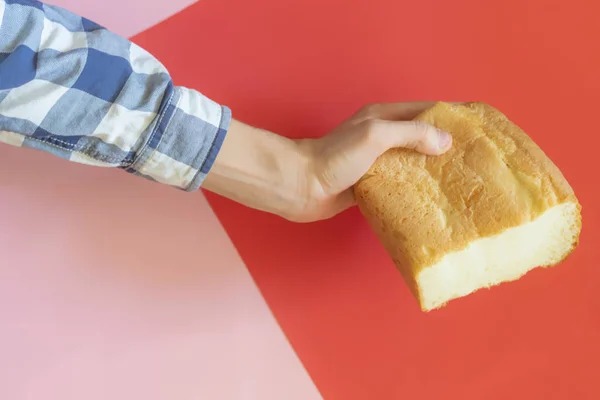 Pohled shora něčí ruky držící bochník chleba přes barvu pozadí f — Stock fotografie
