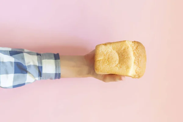 Вид сверху на руку человека с хлебом на цветном фоне — стоковое фото