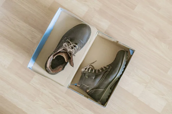 Para nowych butów w pudełku po butach na drewnianej podłodze f — Zdjęcie stockowe