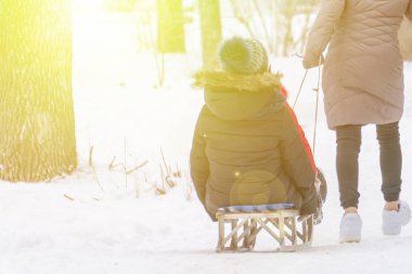 young kid ride sledge with his parents outdoors in winter season b