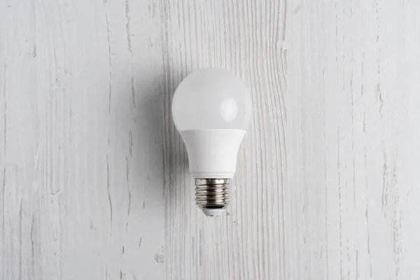 Gloeilamp liggen op witte achtergrond en hand met het b — Stockfoto