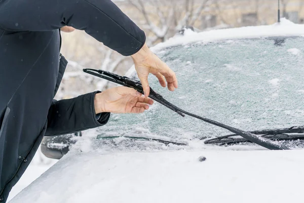 Man adjusting and cleaning wipers of car in snowy weather b — Stock Photo, Image